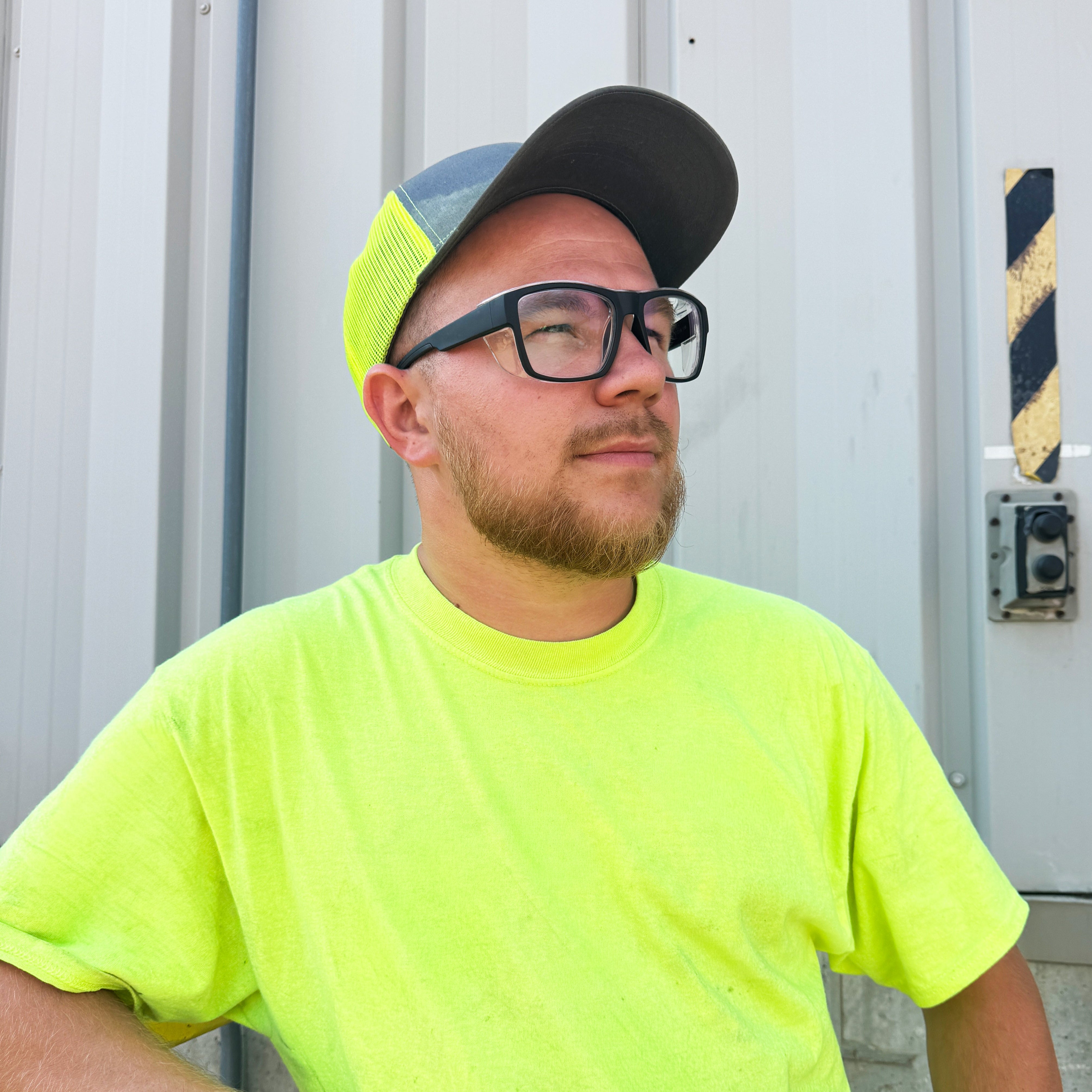 HiDX A001 prescription safety glasses in matte black worn by worker in neon shirt outdoors