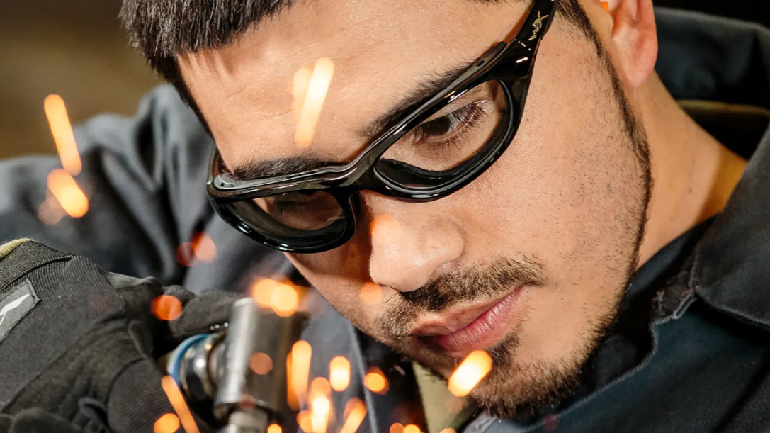 Man wearing a pair of prescription safety glasses with integrated side shields while wearing glasses and welding