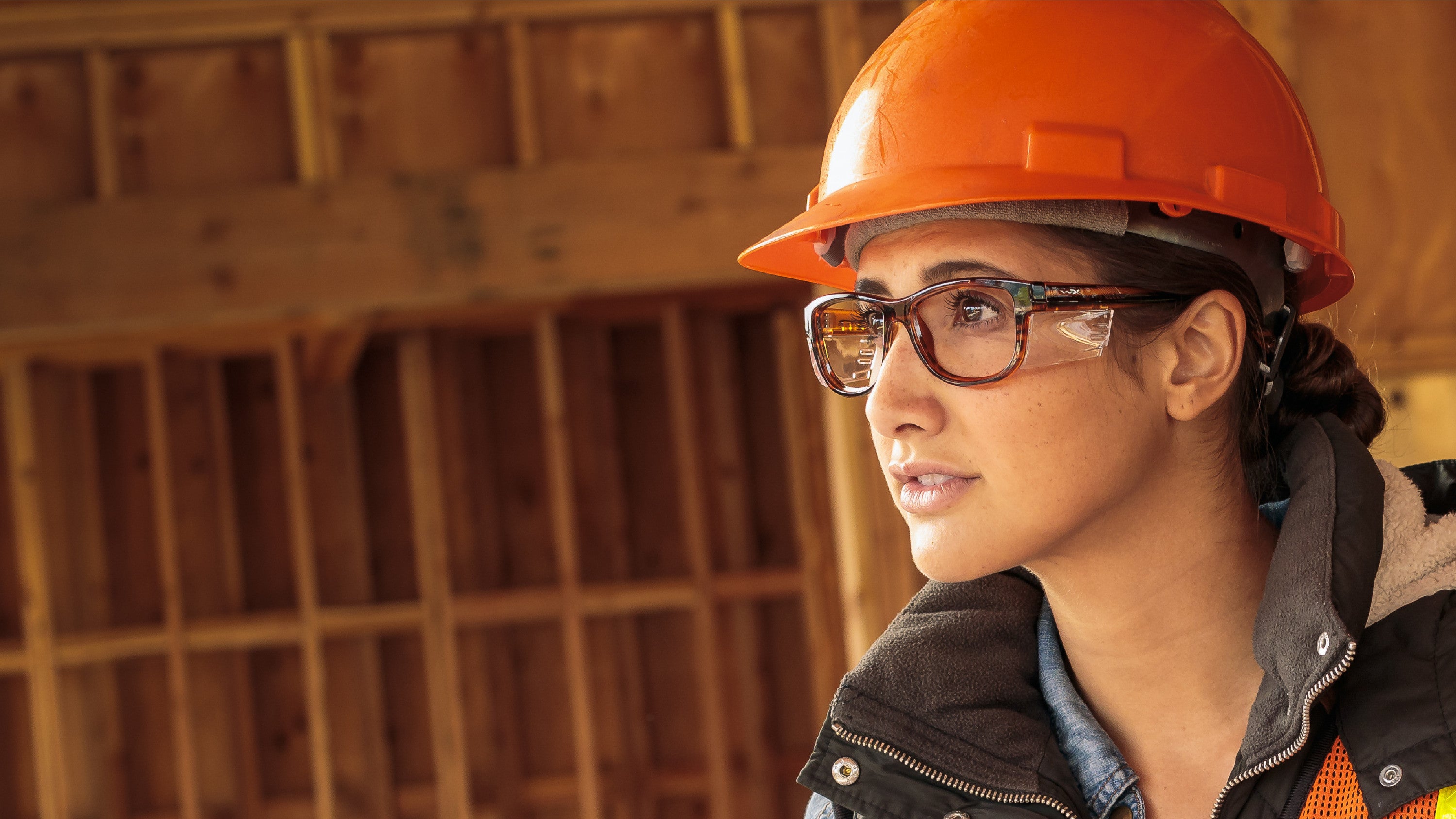 Image of woman wearing tortoise colored glasses at a construction work site