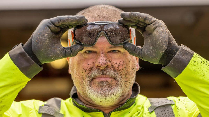 Worker wearing [product name] prescription safety glasses in black, covered in dirt