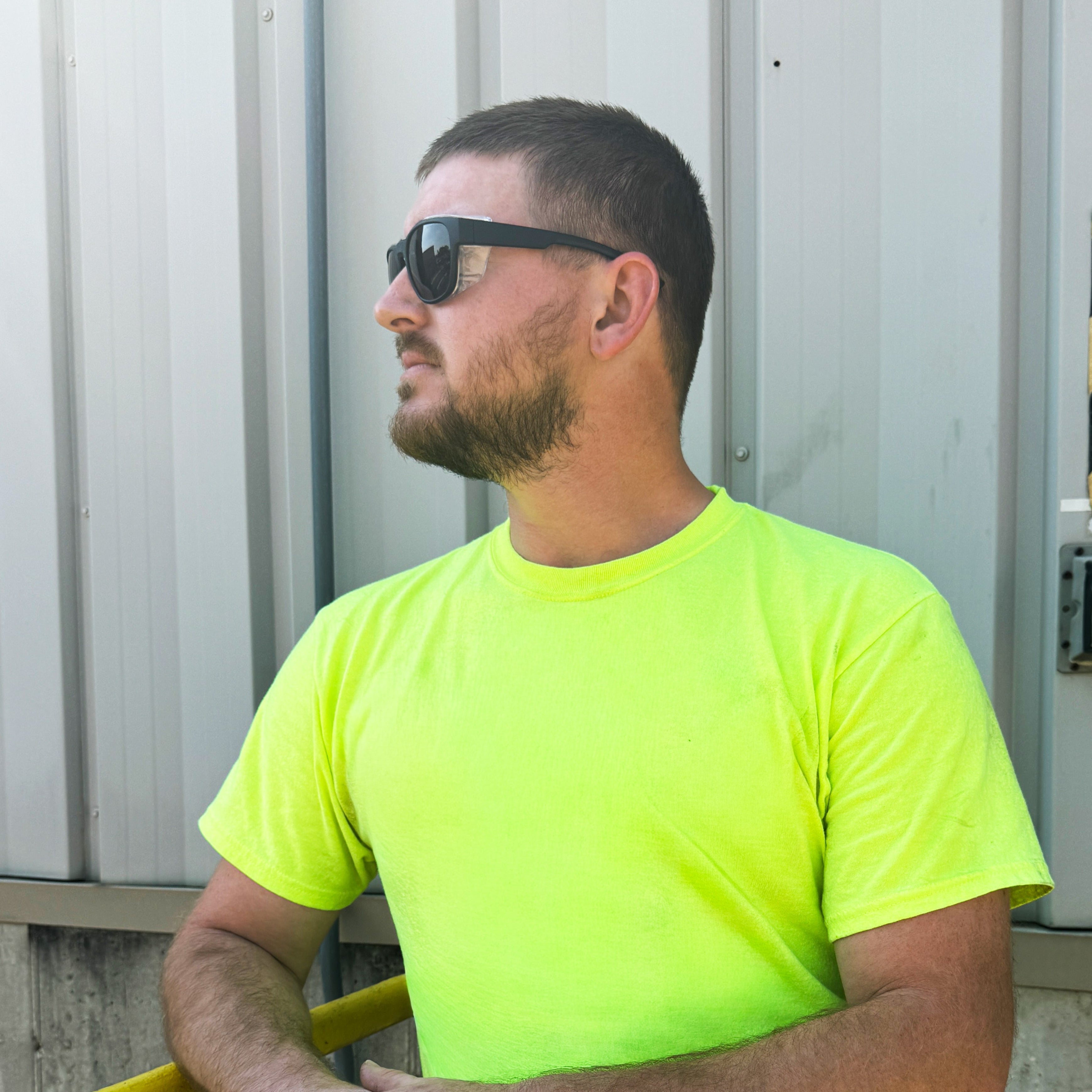 HiDXA002 prescription safety glasses in black worn by man in neon shirt at worksite